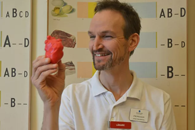 Johan Sundström holds a heart in plastic and smiles. Photo