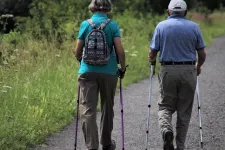 An elderly couple are walking with walking sticks. Photo
